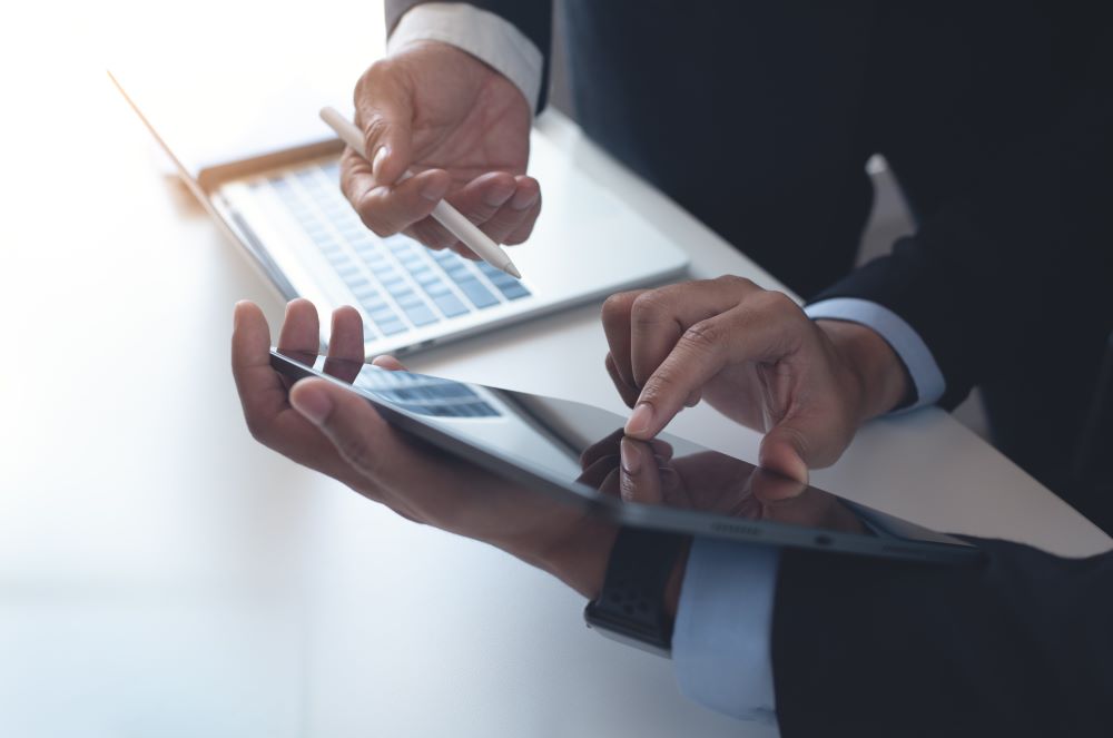 Two businessmen reviewing data on a tablet