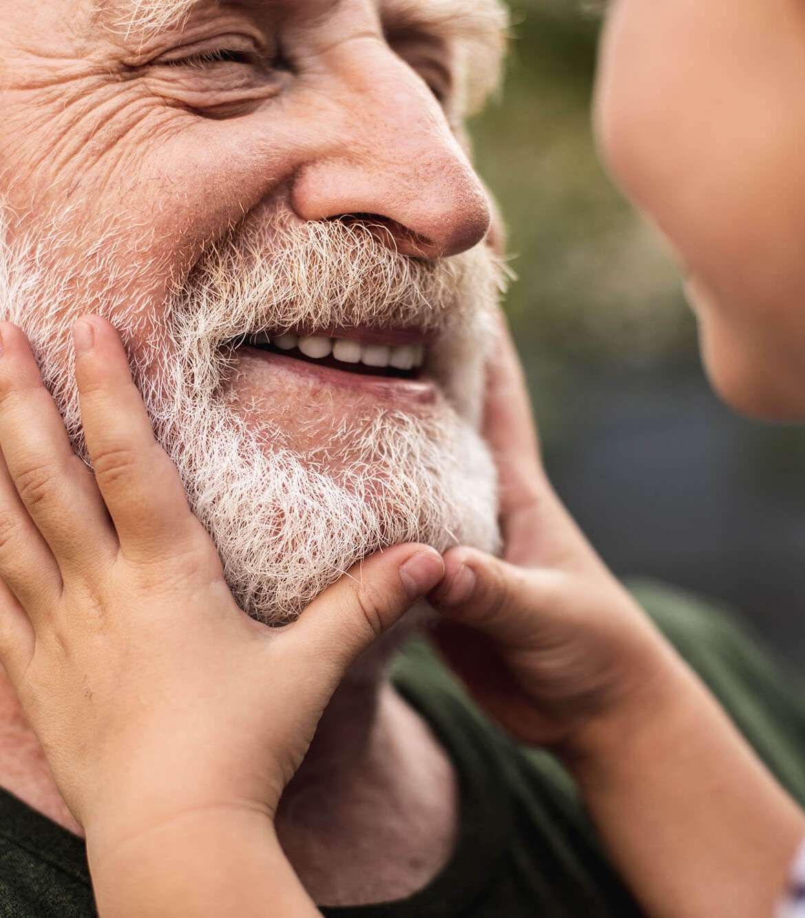 Old smiling man and his granddaughter looking each other